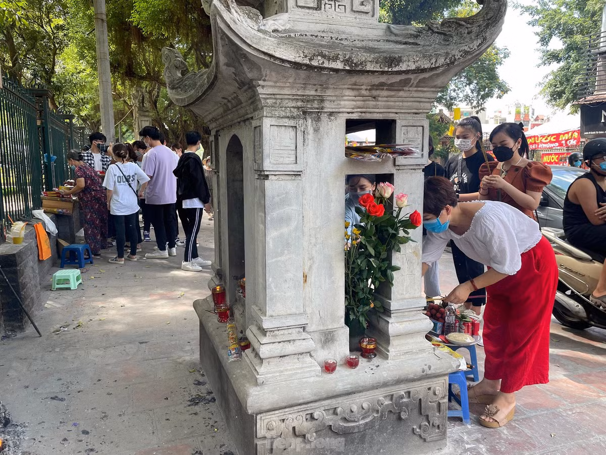 Người dân tranh thủ hóa vàng ngay tại hàng rào Văn Miếu - Quốc Tử Giám sau khi hành lễ. 