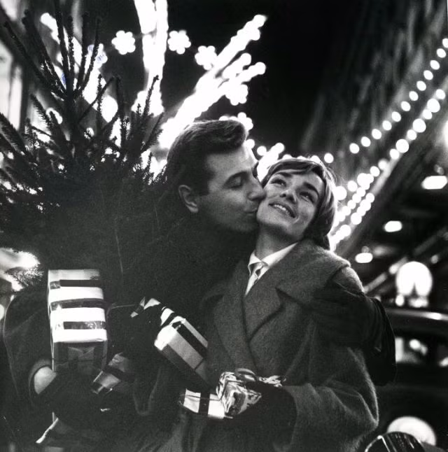 Đôi trai gái trẻ tranh thủ hôn nhau khi đi mua sắm Giáng sinh, Paris năm 1950. Ảnh: Robert Doisneau.