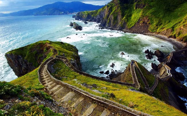 Gaztelugatxe, Tây Ban Nha. Đây là một hòn đảo nằm ngoài khơi bờ biển Biscay, Tây Ban Nha và kết nối với đất liền bằng một cây cầu nhân tạo gồm 237 bậc. Đảo có một nhà thờ nhỏ để tưởng nhớ nhà tiên tri Gioan Baotixita, người được cho là đã đặt chân lên hòn đảo vào thế kỷ thứ 10. Nơi đây nổi tiếng với phong cảnh đẹp và nước biển trong xanh.