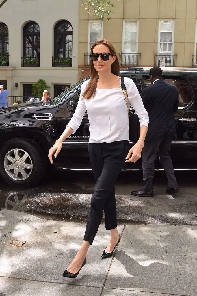 Túi đeo chéo vai cùng quần skinny, áo sơ mi trắng mang đến sự năng động khi Angelina Jolie phải làm việc ngoài trời.