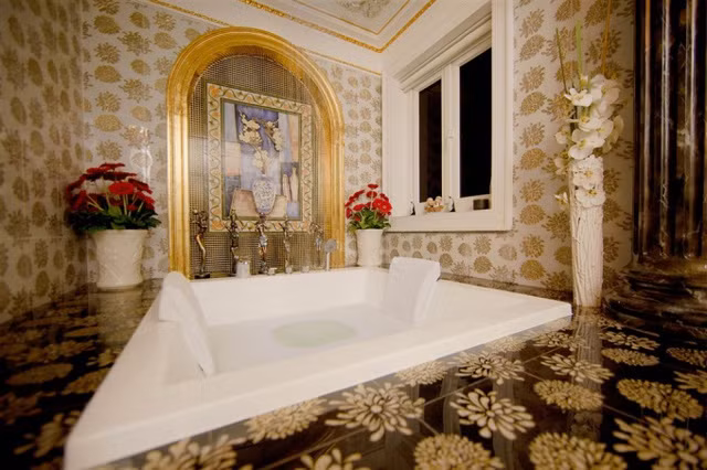 Một mảng tường trong phòng tắm được viền bằng vàng và trang trí các loại hoa tươi. Người đẹp mong muốn mỗi góc nhà là một bức tranh nghệ thuật.