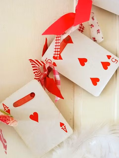 Đơn giản là thu thập những con bài cơ và xâu chuỗi nó cũng bằng ruy băng đỏ gắn trên cửa hoặc ngang lò sưởi để người ấy có thể nhìn thấy ngay khi bước chân vào nhà.