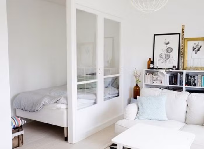 Trong khi mẫu phòng ngủ trong chung cư 20m2 này lại được ngăn cách với phòng khách bằng một khung cửa sổ kính. Ảnh: archzine