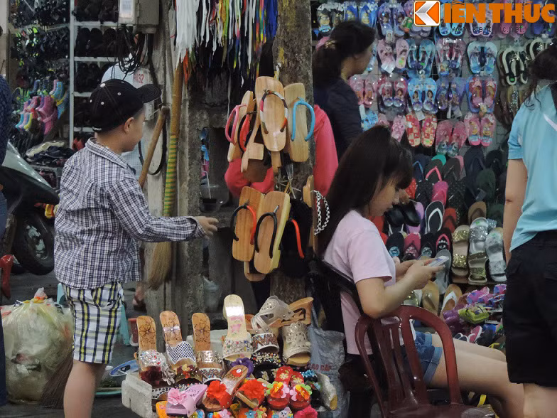 Một loạt cây xanh trên phố Lò Sũ bị người dân tận dụng, biến thành của riêng. Những cây nhỏ, thân khẳng khiu cũng không thể tránh được cảnh đóng đinh, búa. Trong ảnh là giá đỡ bán giày, dép bằng thân cây.