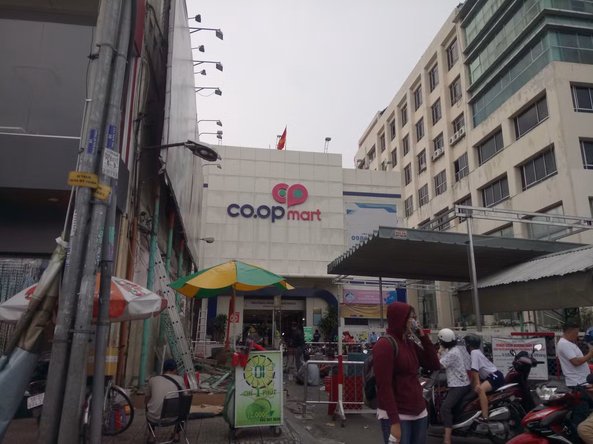 Khach ngo ngang truoc tin Co.opmart Dinh Tien Hoang dong cua