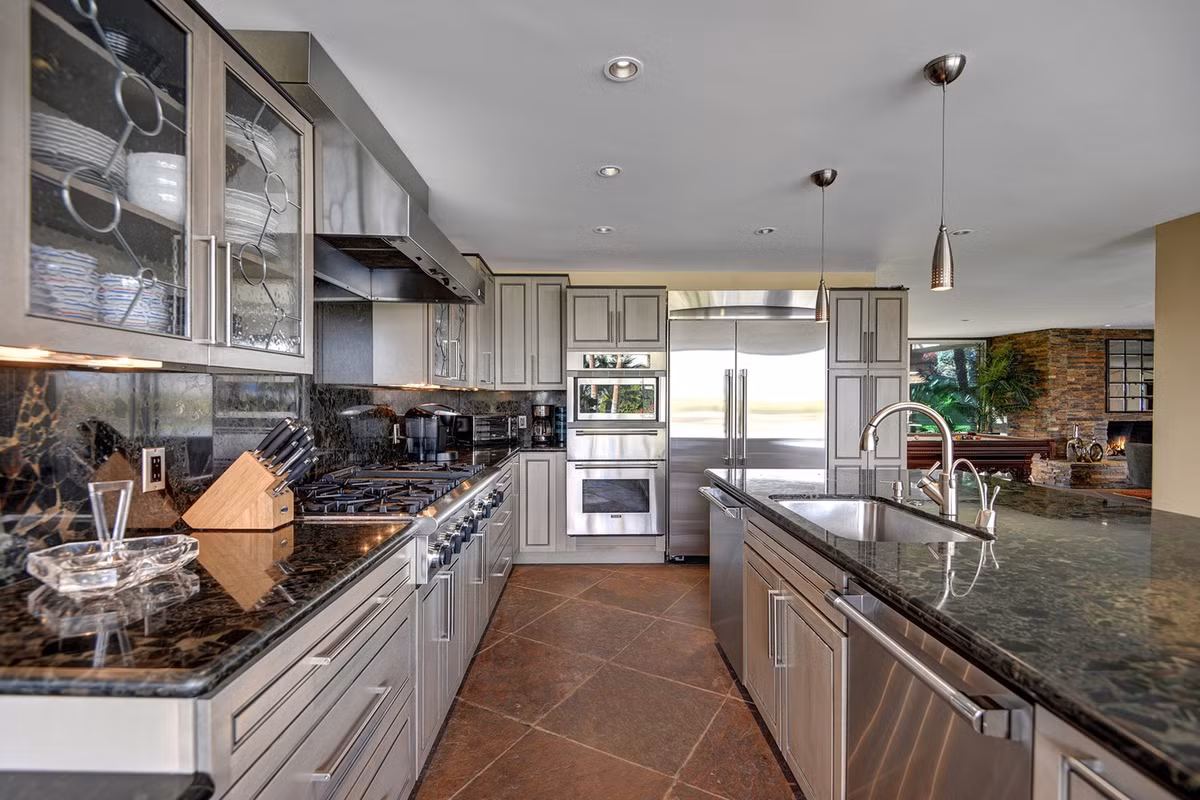 Nhà bếp hiện đại có quầy bar ăn sáng, mặt bếp bằng đá granite và các thiết bị bằng thép không gỉ.