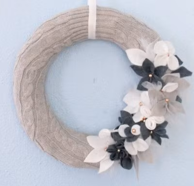 Vòng hoa giáng sinh. Tạo một vòng hoa ấm cúng trong mùa đông với len rất đơn giản. Chỉ cần một cái khung tròn để quấn len xung quanh và đính kèm hoa, hạt ngọc trai, trông đặc biệt sang trọng.