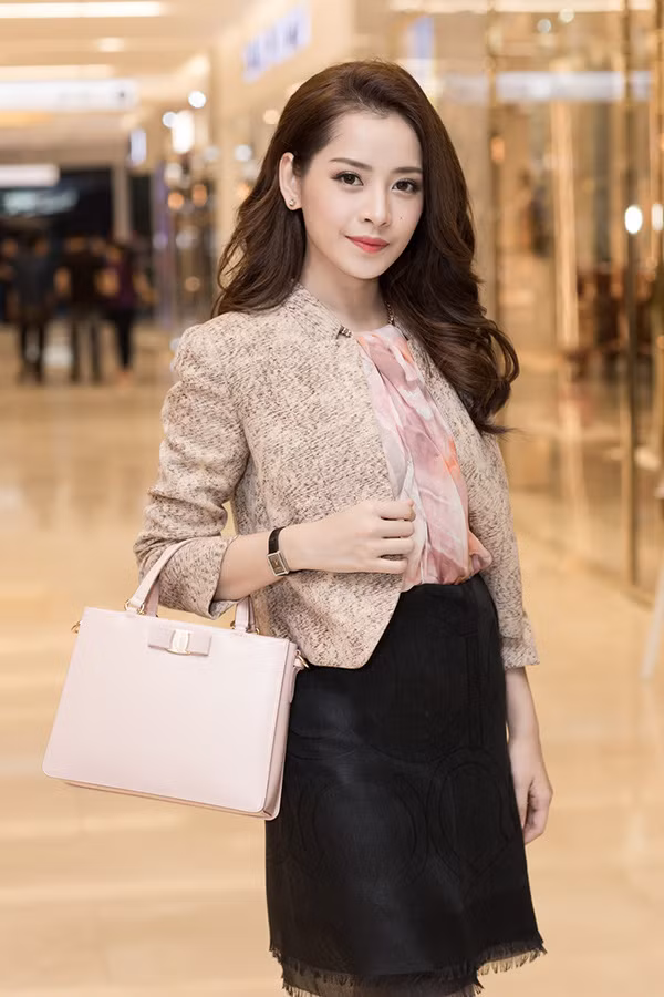 Cũng hưởng ứng mốt khăn quấn thành áo này, Chi Pu khéo léo kết hợp với chân váy đen và áo khoác nhẹ nhàng thanh lịch.