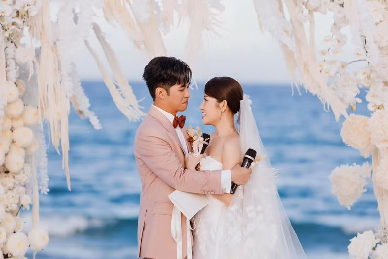 "Cảm ơn em vì đã luôn yêu thương, ở bên cạnh anh trong tất cả mọi chuyện. Dù thử thách, sóng gió nhưng cuối cùng chúng ta đã vượt qua được. Hôm nay, chúng ta đến với một chương mới của cuộc đời, trước sự chứng kiến của ba mẹ, gia đình và tất cả bạn bè, đồng nghiệp. Anh sẽ không thề, vì đó chỉ là một lời nói suông. Anh vẫn sẽ làm những điều hàng ngày đã làm cho em, để em cảm nhận được yêu thương từ anh. Cảm ơn em, vợ của anh. Anh yêu em", Người Đưa Tin dẫn lời Gin Tuấn Kiệt. Ảnh: FBNV.