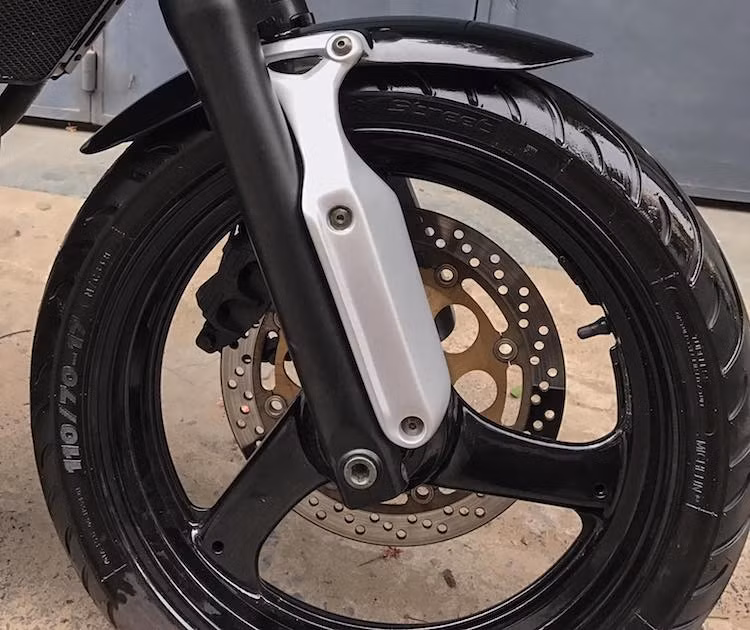 Trên bản độ môtô cafe racer này, LeeAT đã giữ lại khá nhiều các chi tiết nguyên bản của chiếc Bandit, trong đó có hệ thống phanh và cặp mâm 3 cây khỏe khoắn. Bắt đầu từ phía trước, bộ dè bánh trước đã được xưởng độ này chế lại với tai bắt dài màu ánh bạc, khiến dáng của chiếc xe trở nên khác biệt hơn đôi chút.
