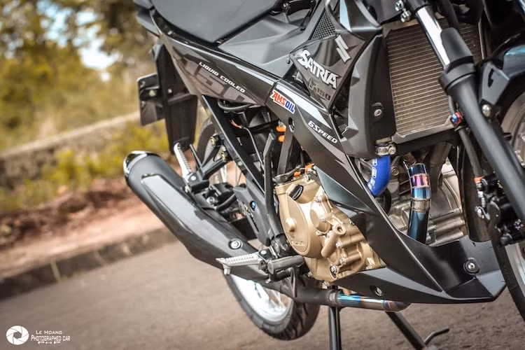 Về "nội công", khối động cơ 1 xi-lanh DOHC 150 cc đã được cải tiến để có thể đạt công suất lên tới 18 mã lực và mô-men xoắn 13,8 Nm của Satria Fi được giữ nguyên kết cấu bên trong, chỉ nâng cao độ bền bỉ khi hoạt động nhờ lọc gió K&amp;N, ống giải nhiệt Samco và cổ pô titan. Ống xả nguyên bản của xe cũng được giữ nguyên, chỉ có ốp chống nóng thay bằng carbon.