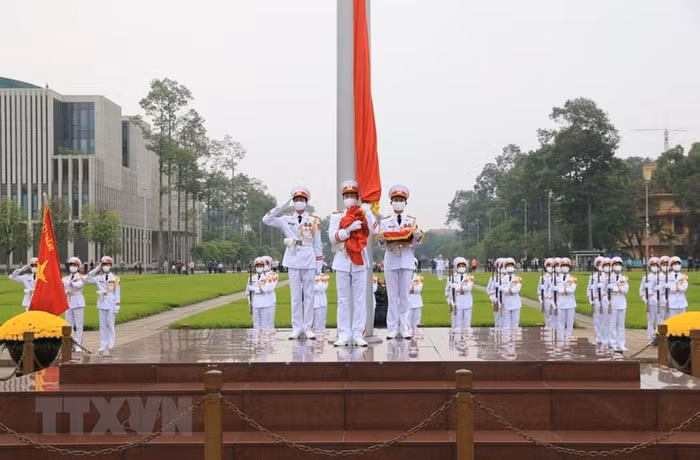 3 chiến sĩ hồng kỳ nghiêm trang bước lên bục chuẩn bị thực hiện nghi thức thượng cờ. (Ảnh: Thành Đạt/TTXVN) 