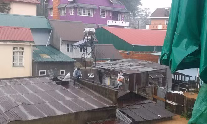 Lúc này, xuất hiện một thanh niên mặc áo mưa trắng tìm đường lên mái tôn, mặc cho mọi người ngăn cản. Người này lấy cây sắt dỡ mái tôn, đưa em bé khoảng 1 tuổi sang nhà khác.