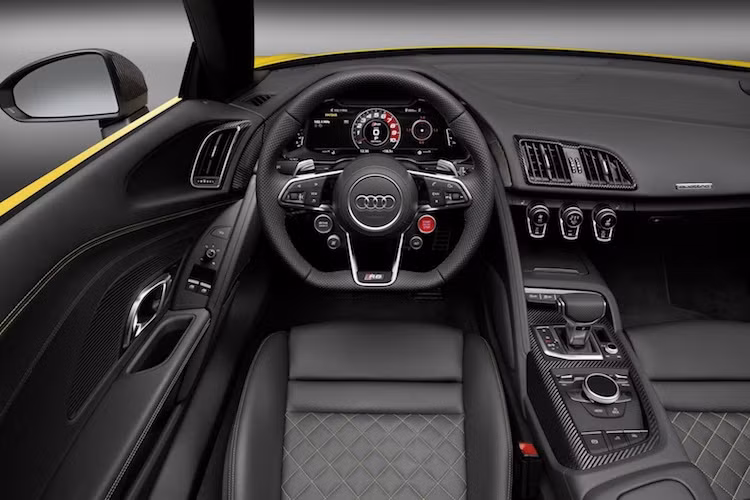 Các chi tiết thiết kế còn lại của R8 Spyder, bao gồm cả nội thất hoàn toàn giống như R8 Coupe. Xe có bảng điều khiển tối giản, bảng đồng hồ kỹ thuật số Virtual Cockpit và những chiếc ghế bọc da chần chỉ vân con thoi sang trọng. Đương nhiên, với bộ mui xếp mới, R8 Spyder sẽ có thêm một nút bấm đóng mở mui trên bệ điều khiển trung tâm bằng sợi carbon.