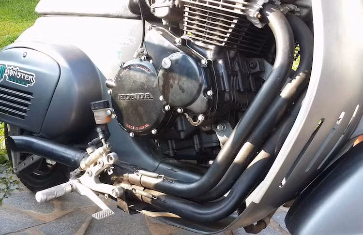 Với khối động cơ quá lớn choán hết hoàn toàn vị trí để chân nguyên bản của Vespa 50 S, những người thợ độ đã phải lắp dàn để chân của xe phân khối lớn thông thường ở hai bên thân xe. Ngoài ra để làm mát cho động cơ, phần yếm xe cũng đã được cắt lỗ dọc.