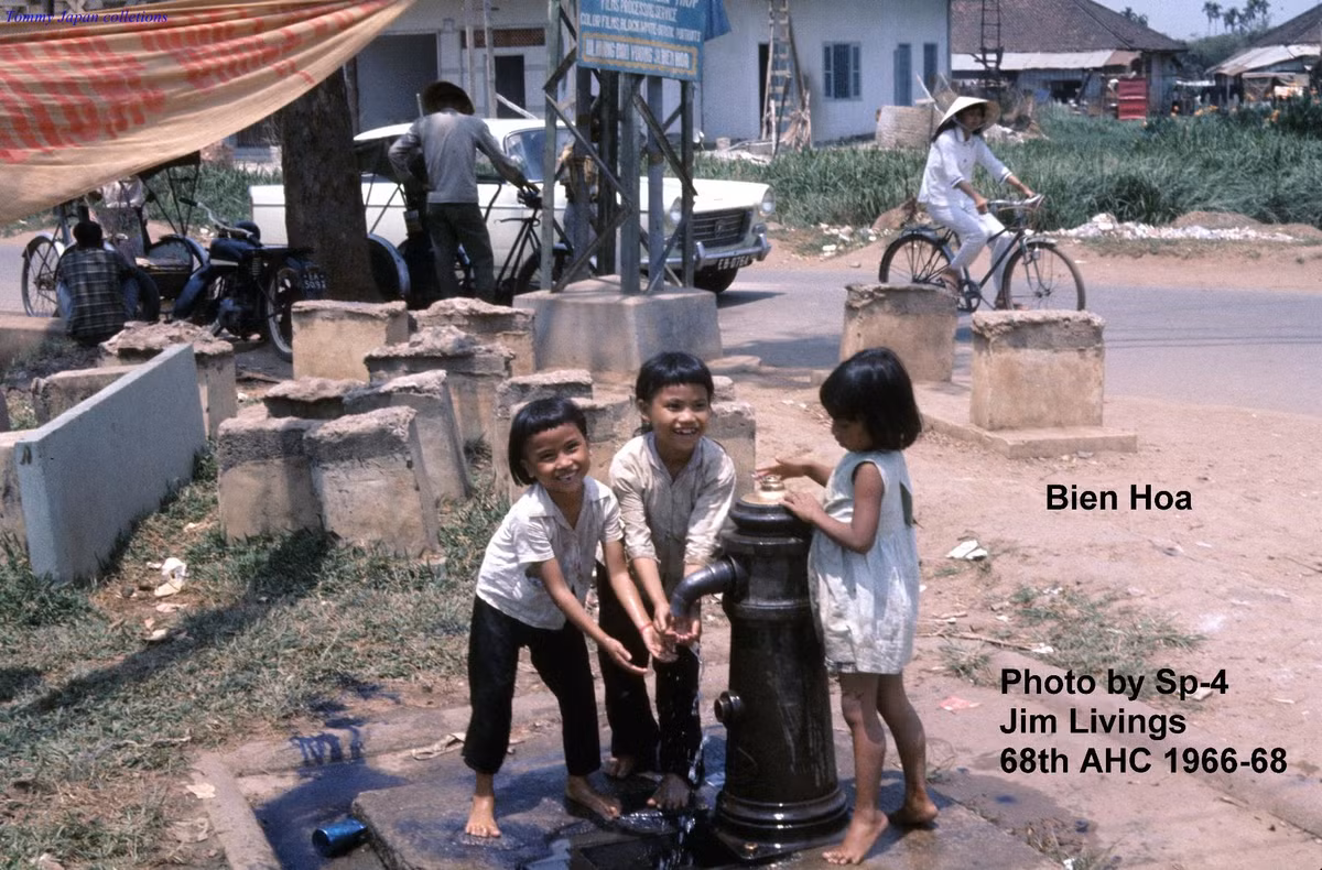 Các em bé bên vòi nước công cộng. Ảnh: Jim Livings.