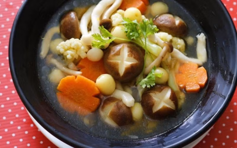  Canh nấm chay: Sơ chế nấm, cà rốt, bí đỏ cắt thành miếng vừa ăn, hạt sen tách bỏ tâm sen, rửa sạch để ráo nước. Rau mùi tàu thái khúc 0.5cm, hành boa rô thái nhỏ để riêng. Sau đó xào cà rốt, bí đỏ, hạt sen, nấm với 1 thìa mắm, 1/2 thìa đường và 1 thìa hạt nêm. Sau khi xào chín, đổ khoảng 1 lít nước vào nồi, đợi nước sôi đun vặn nhỏ bếp đến khi chín mềm. Cuối cùng cho bông cải và nấm bạch tuyết vào đun trong 3 - 5 phút, nêm nếm lại cho vừa ăn. Ảnh minh họa