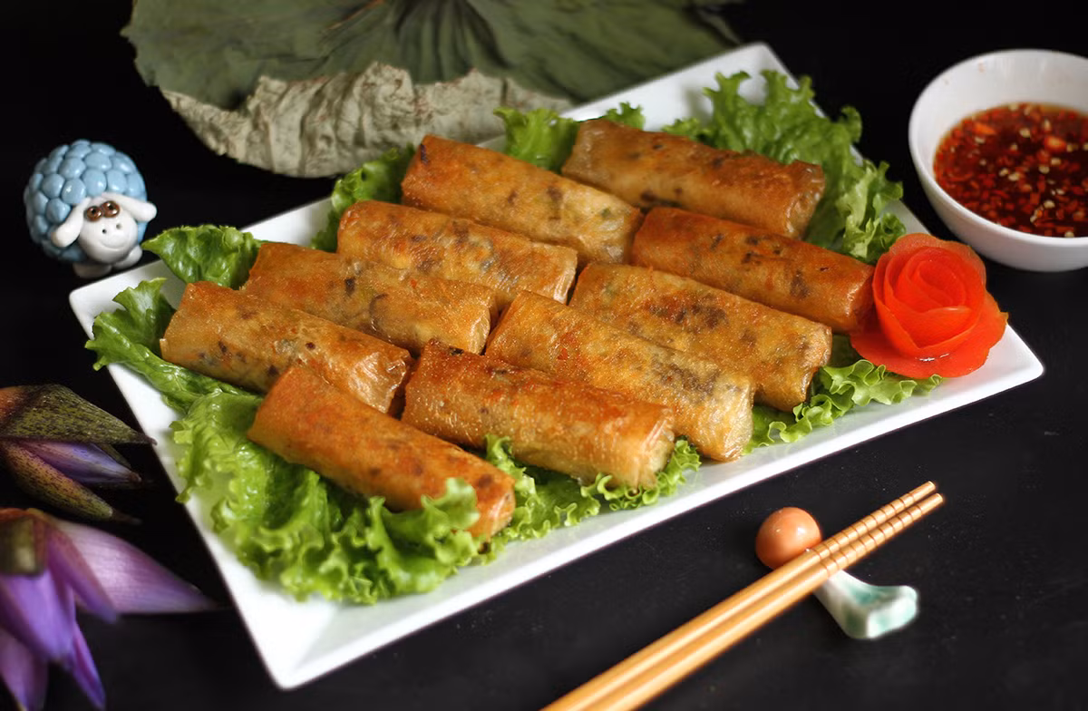  Chả ram chay: Khoai lang và cà rốt bào sợi, trộn đều với đậu xanh đã hấp chín, boa rô bằm nhỏ, tiêu, muối, bột ngọt. Cho nhân vào bánh tráng, gấp hai bên bánh tráng lại rồi cuốn. Cuốn vừa tay không chặt quá vì sẽ bị bung nứt khi chiên, cuốn nới tay quá thì chả ram sẽ bị nhiều dầu hút vào không ngon. Khi cuốn chả ram nên dùng ít giấm pha loãng với nước để thoa lên bánh tráng khi cuốn. Ảnh Internet