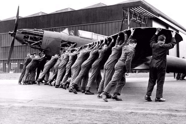 Những học viên cùng nhau hợp sức đẩy một chiếc Fairey Battle vào nhà chứa tại trường đào tạo kỹ thuật ở Cosford, Shropshire. Ảnh chụp năm 1940.