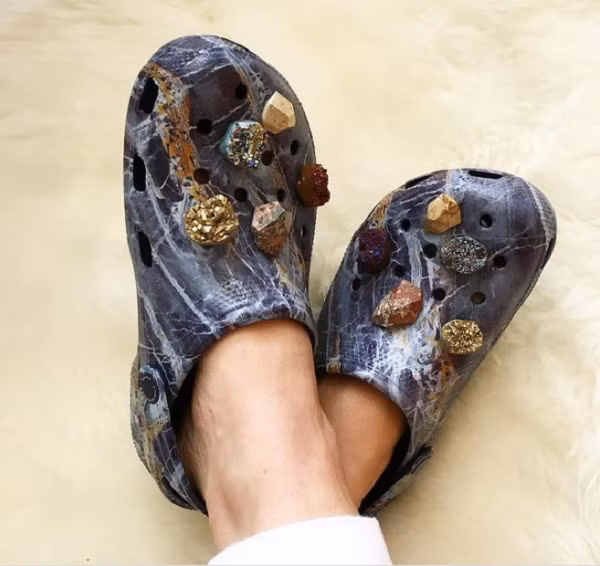 Đôi crocs này là tác phẩm của nhà thiết kế người Anh Christopher Kane. Nó được xem là đôi "dép của người giàu" vì phủ toàn đá quý.