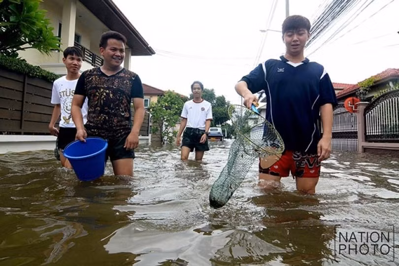 Một số người hào hứng mang cả lưới bắt cá khi đường phố ngập lớn.