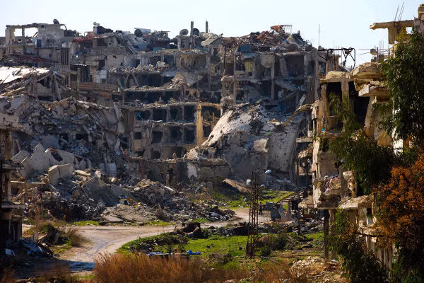 Cuộc nội chiến Syria đã tàn phá nặng nề quốc gia Trung Đông này và khiến khoảng 4,8 triệu người dân Syria phải sơ tán. Ảnh: Một người đàn ông Syria đi qua những tòa nhà đổ nát ở Homs ngày 26/2/2016.