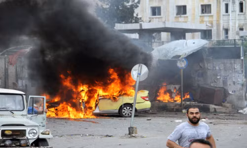 Những em học sinh Syria đi qua đống đổ nát ở Jobar, ngoại ô thủ đô Damascus, ngày 30/4.
