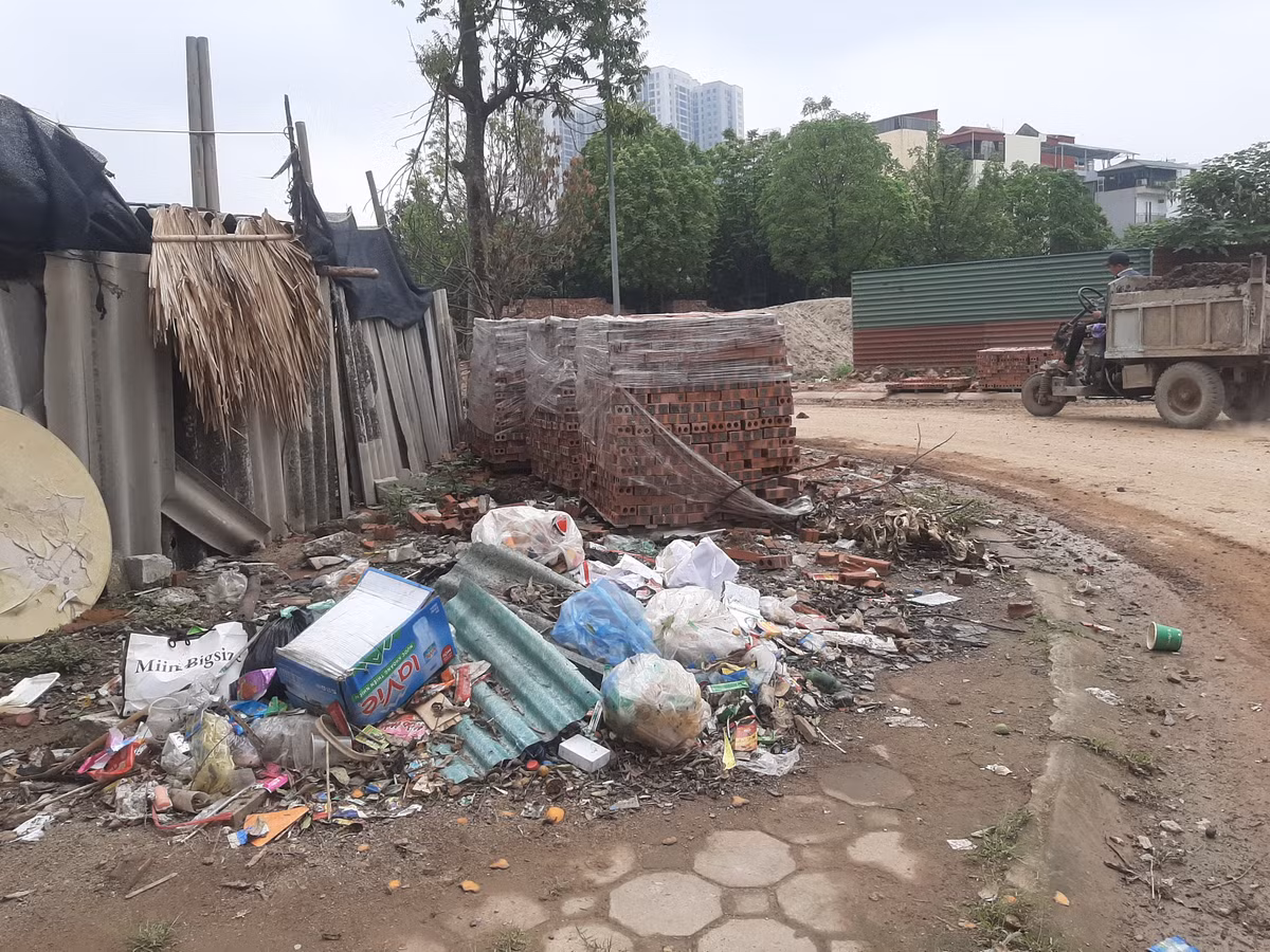 Anh Lê Minh Đức (quận Hà Đông) bức xúc: "Vỉa hè phố Nông Quốc Chấn ngập ngụa các loại rác thải sinh hoạt, bốc mùi hôi thối, gây ô nhiễm môi trường. Ngoài ra, vỉa hè còn bị chiếm dụng để tập kết vật liệu xây dựng khiến diện mạo khu phố trở nên nhếch nhác". Một góc vỉa hè phố Nông Quốc Chấn trở thành "điểm đen" tập kết rác thải và vật liệu xây dựng. (Ảnh Quang Thành)