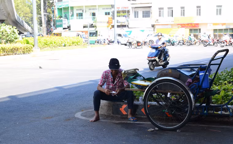Người chạy xích lô trên đường 3/2, quận 10 không chịu nổi thời tiết gay gắt phải dừng lại dưới gầm cầu vượt để trốn nắng.