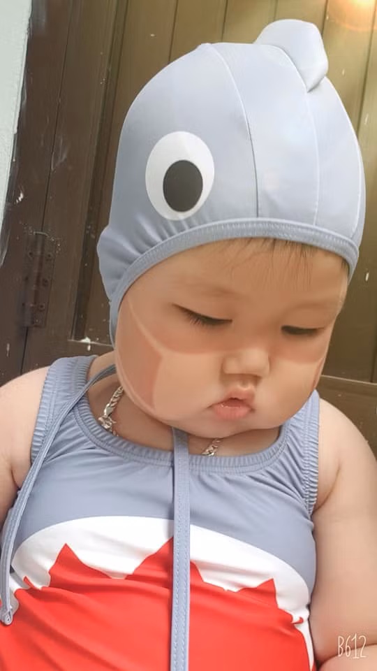Bà mẹ đứa trẻ này đã đăng tải hình ảnh con mình lên kèm theo dòng trạng thái cực đáng yêu :"Giận bà mẹ hết sức à, đã nói nắng nóng không thích đi biển rồi mà cứ bắt đi. Giờ thì bà hài lòng chưa". Từ đó, ngôi sao nhí bỗng chốc nổi tiếng vì quá đáng yêu, bụ bẫm trong bộ đồ bơi.