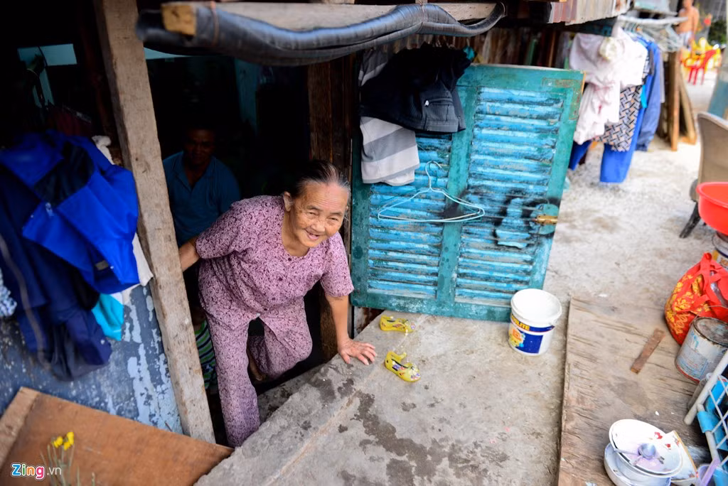 Bà Nguyễn Thị Tạo (83 tuổi) cho biết trước kia nhà bà cách xa đường vài mét, ngang mặt đường. Nhưng từ khi nâng cao và mở rộng đường đã khiến tổ ấm của gia đình này bị tiến sát mép đường, không có lối đi. Bà Tạo phải lọm khọm chui lên chui xuống.
