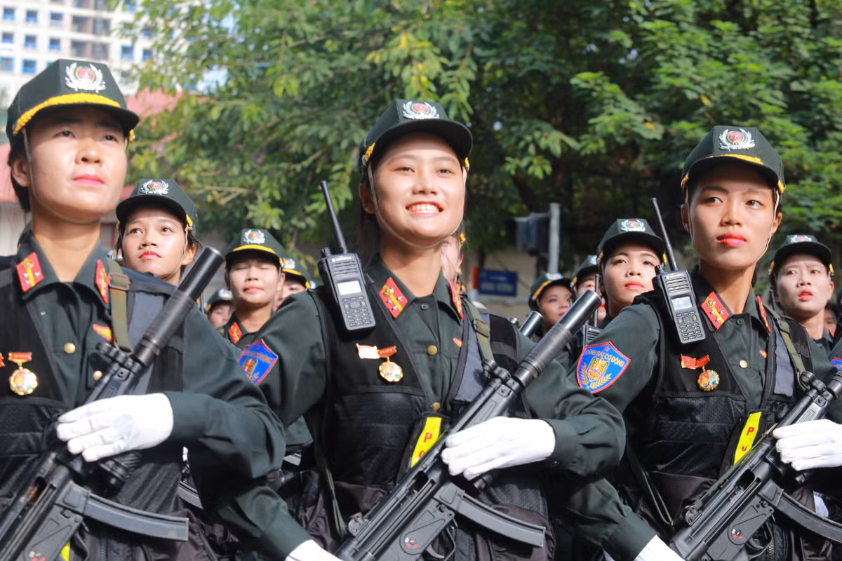 Nụ cười tươi rói nữ chiến sĩ cảnh sát cơ động vinh dự là một phần của lễ diễu binh hoành tráng.