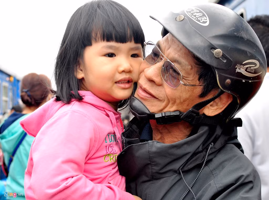 Ông Trần Thẩm (70 tuổi, ngụ thị trấn Sông Vệ, huyện Tư Nghĩa) mừng vui ôm cháu ngoại theo mẹ vừa về cho thỏa nỗi nhớ mong sau một năm dài xa cách. "Cuộc sống dẫu còn nhiều khó khăn nhưng mỗi dịp xuân về, vợ chồng tôi đều đi xe máy vượt hơn 15 km từ quê ra ga Quảng Ngãi đón con, cháu từ TP.HCM về vui Tết đoàn viên cùng ông, bà", ông Thẩm nói.