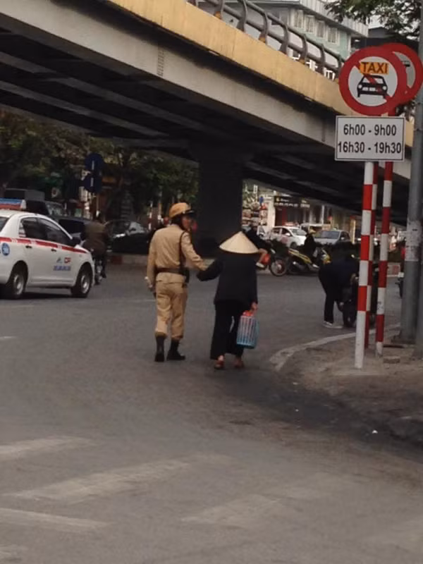 CSGT Hà Nội dẫn dắt cụ bà lớn tuổi đi đúng đường, một cách an toàn.