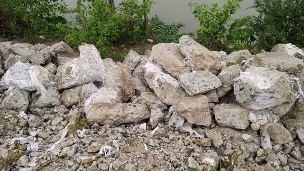Các lớp bê tông sau khi đào lên được chất đống ngổn ngang ngay dọc bờ đê sông Nhuệ.