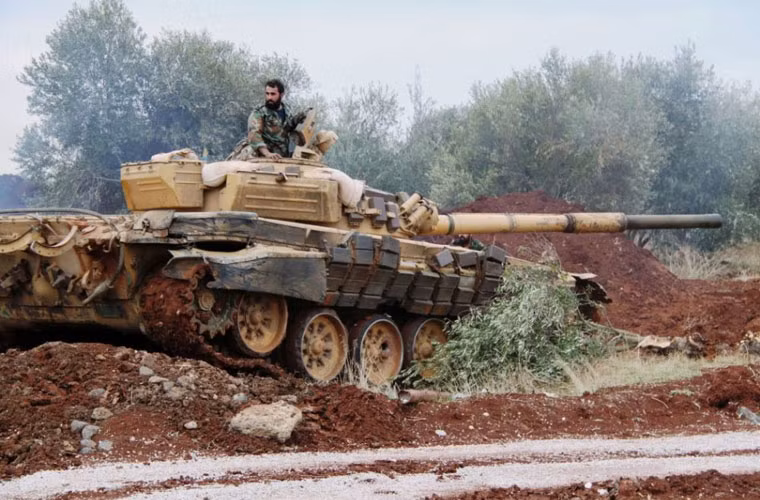Xe tăng T-72AV đảm bảo an ninh quanh căn cứ máy bay chiến đấu Không quân Syria tại Hama.
