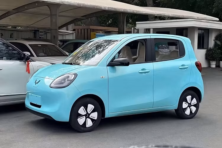 Sự xuất hiện của màn hình thông tin giải trí khiến cửa gió trung tâm và các núm xoay chỉnh điều hòa đều được chuyển xuống phía dưới. Bên cạnh đó là 2 cửa gió hình tròn nằm ở hai góc của mặt táp-lô. Ghế của Wuling Hongguang Mini EV 5 cửa được bọc bằng nỉ màu sáng, tạo cảm giác thanh lịch. Ở giữa 2 ghế trước là núm xoay chuyển số điện tử.