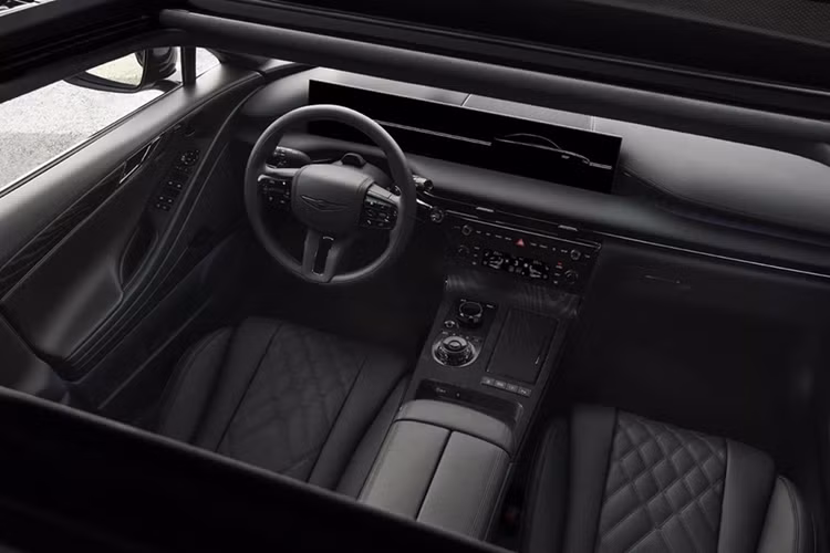 Khoang lái của Genesis G80 Black cũng lấy màu đen làm chủ đạo. Các chi tiết như cần số, núm chọn chế độ lái, bệ cửa, loa, logo hãng hay ghế da chần bông đều được phủ màu đen. Bảng táp-lô, bệ trung tâm và tapi cửa có chèn gỗ Black Ash. Phía sau vô lăng là cụm màn hình kích thước 27 inch, hiển thị ảnh động chào mừng và tạm biệt độc quyền.