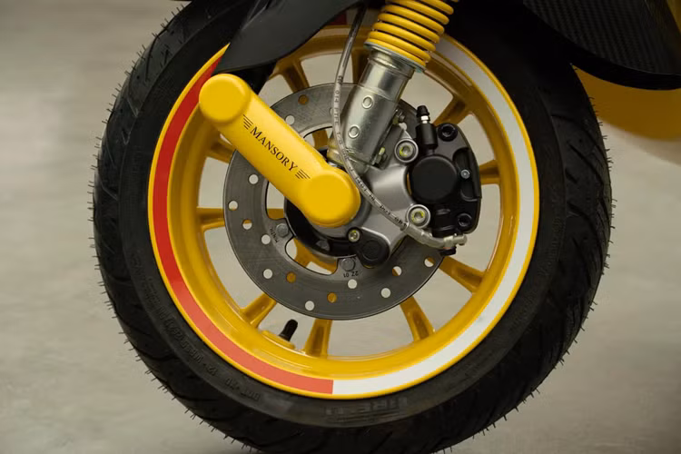 Vespa Primavera Elettrica bổ sung nhiều chi tiết bằng sợi carbon từ phần ốp đầu xe, vè trước, khung viền của đèn xi-nhan, thanh đỡ chân sau và bổ sung thêm đèn chiếu sáng phụ cùng hoạ tiết màu cờ của Công quốc Monaco.