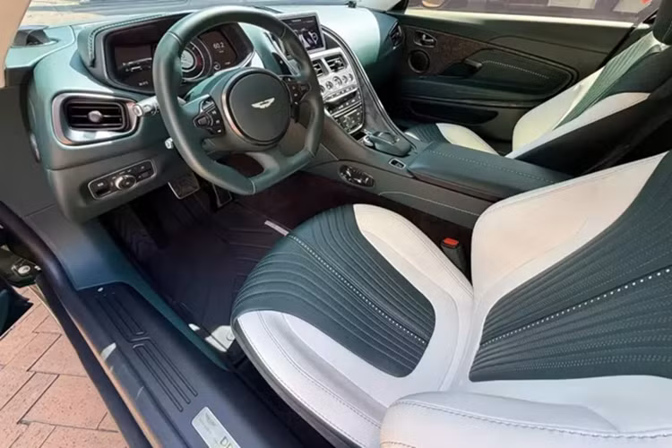 Khi cánh cửa chim 45 độ của xe Aston Martin DB11 V8 được mở ra sẽ khiến khách hàng choáng ngợp trước các vật liệu cao cấp như da đắt tiền, nhôm và cả sợi carbon. Chiếc xe Aston Martin DB11 V8 này phối 2 màu nội thất là xanh và trắng. Bảng điều khiển trung tâm ngoài bọc da còn có thêm sợi carbon nhám.