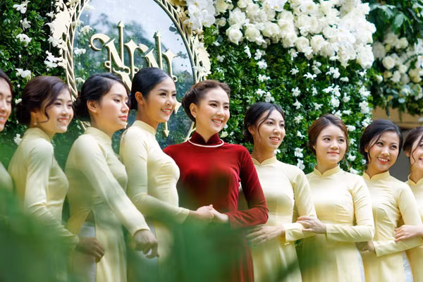 Giữa dàn phù dâu diện trang phục áo dài màu vàng và trắng, Mai Ngọc nổi bật với chiếc áo dài nhung màu đỏ, cùng với vẻ rạng rỡ, nụ cười tươi rói luôn nở trên môi.