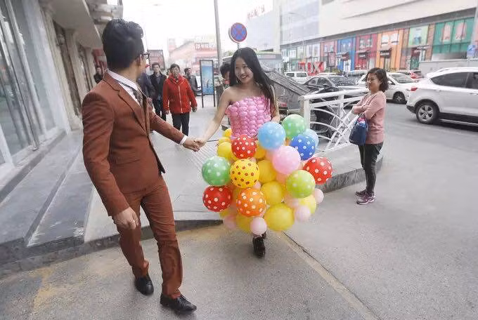 Lu Kepeng và vợ chưa cưới dắt tay nhau hạnh phúc trên đường ở thành phố Thanh Đảo trước ánh mắt ghen tị của mọi người.