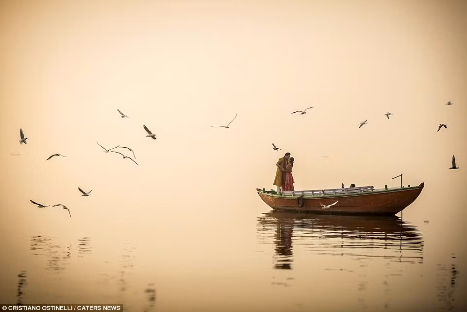 Một cặp đôi chụp ảnh cưới trên thuyền dưới sông ở Varanasi, Ấn Độ.