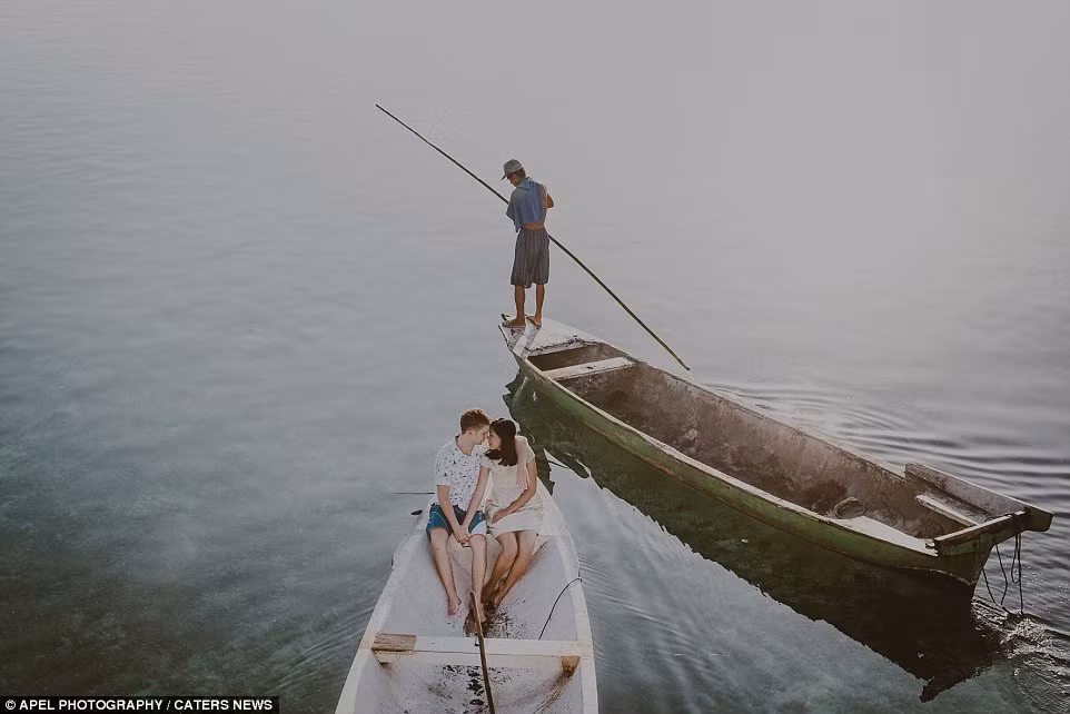 Cặp đôi trẻ tuổi chụp ảnh tình tứ bên nhau trên thuyền tại đảo Lembongan ở Bali, Indonesia.