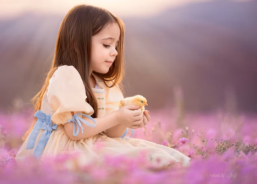 Công chúa nhỏ nâng niu gà con mới nở trên tay của mình.