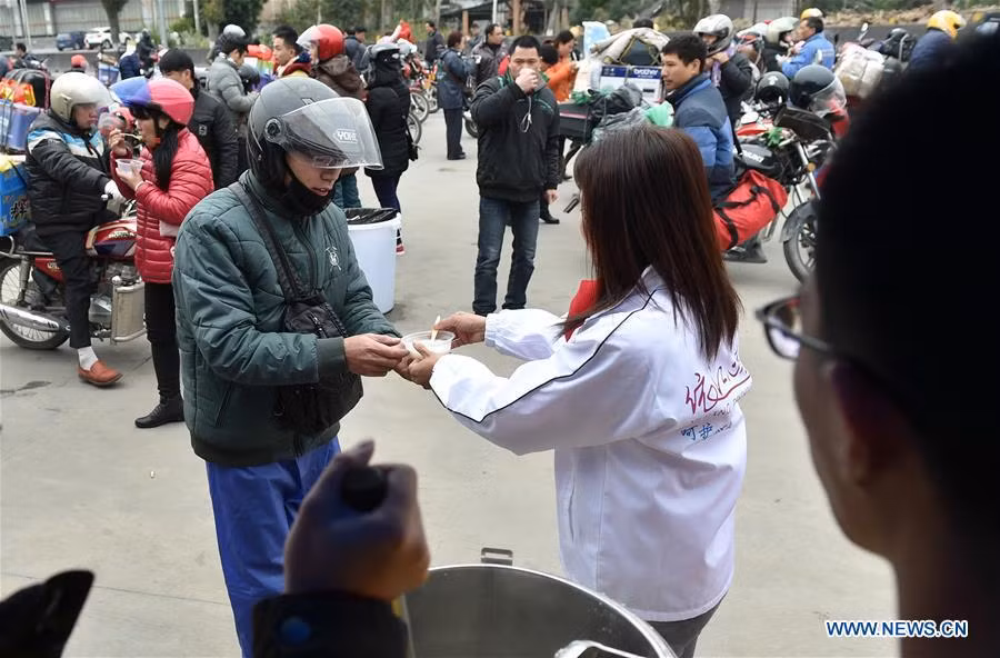Những người lao động xa xứ lái xe máy trên đường quốc lộ 321, đoạn qua Fengkai, tỉnh Quảng Đông, phía nam Trung Quốc. Ảnh: Một tình nguyện viên mời các tài xế dùng cháo miễn phí tại trạm dừng chân Xiaoxiang, Triệu Khánh, tỉnh Quảng Đông..