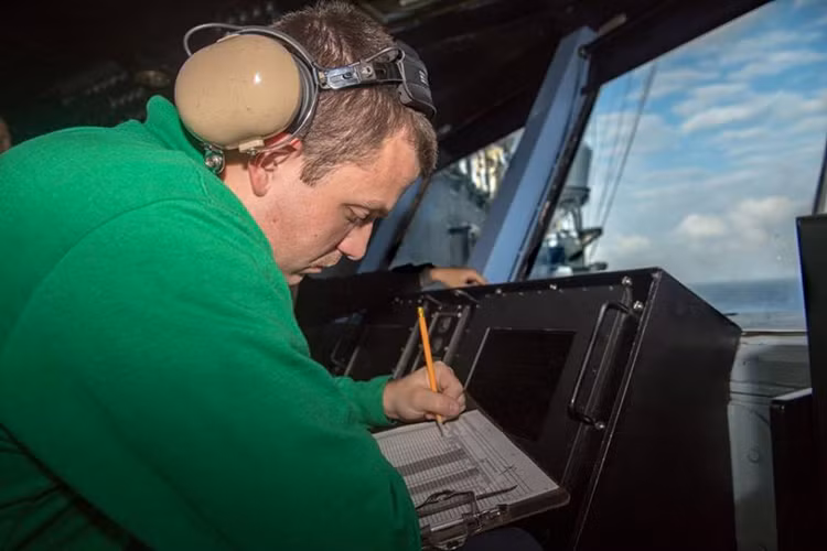 Một sĩ quan ghi lại thông tin chuyến bay từ đài không lưu. Nguồn ảnh: US Navy.