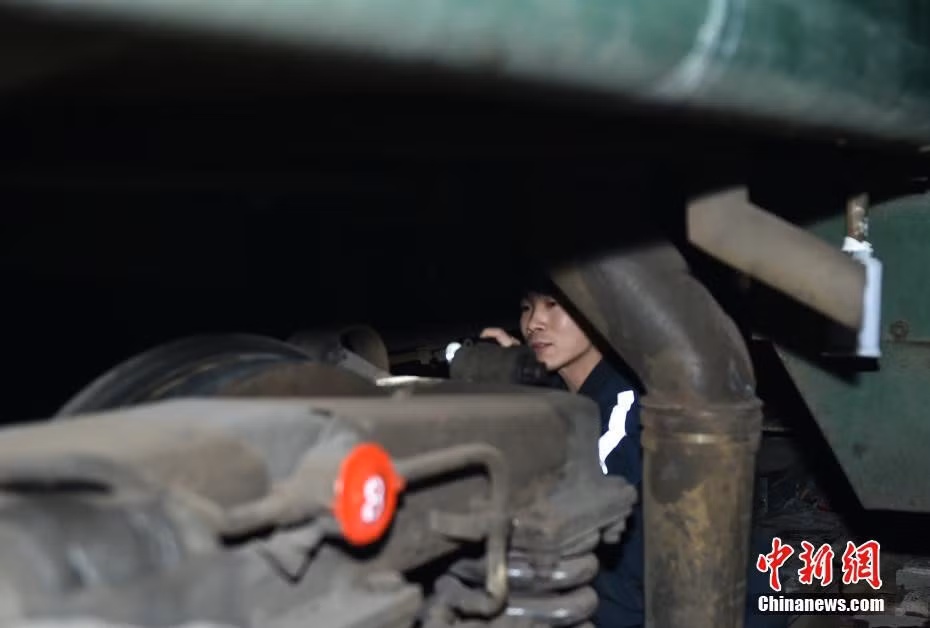 Một nhân viên đường sắt kiểm tra kỹ thuật trước khi tàu chạy. Trước kỳ xuân vận năm nay, toàn Trung Quốc có thêm khoảng 3.000 km đường sắt mới. Ảnh: China News.
