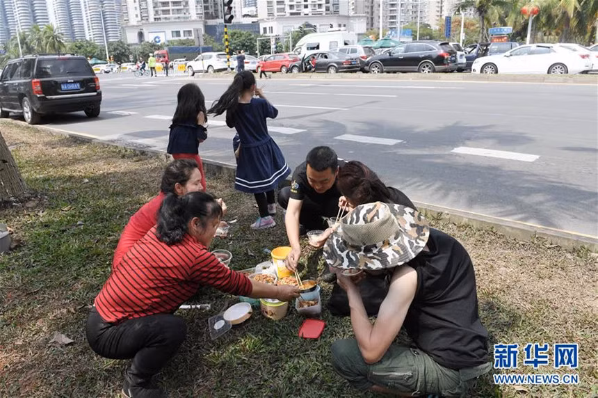 Người đi xe phải xuống đường ăn uống, nghỉ ngơi chờ phà. Hầu hết xe mắc kẹt tại đường vào cảng hơn 2 ngày. Ảnh: Xinhua.