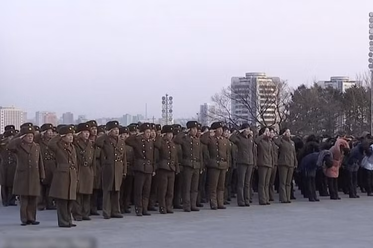 Quân nhân Triều Tiên giơ tay chào khi họ đặt hoa tại tượng các cố lãnh tụ của Triều Tiên là Kim Nhật Thành (Kim Il-sung) và Kim Chính Nhật (Kim Jong-il) ở đồi Mansu, Bình Nhưỡng. Ảnh: AP.